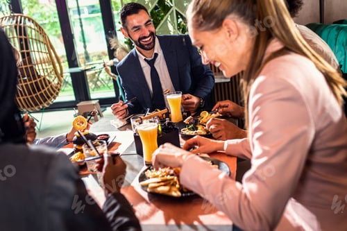 Preview: Group of business people in restaurant at lunch.