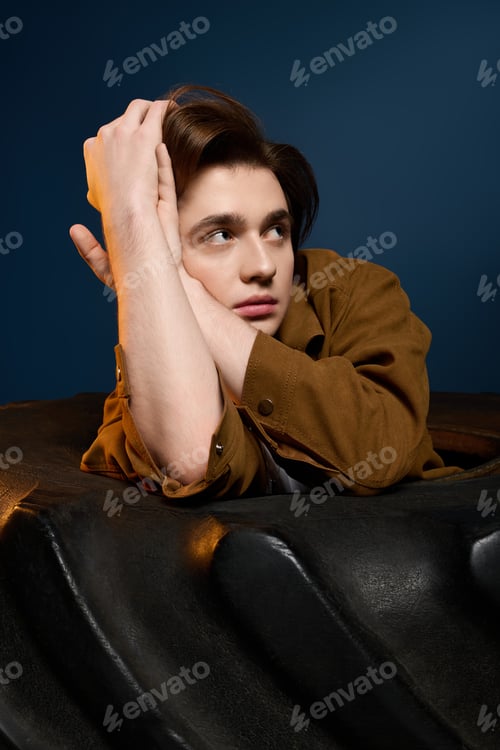 Preview: Young fashionable man poses thoughtfully in a modern setting with striking backgrounds