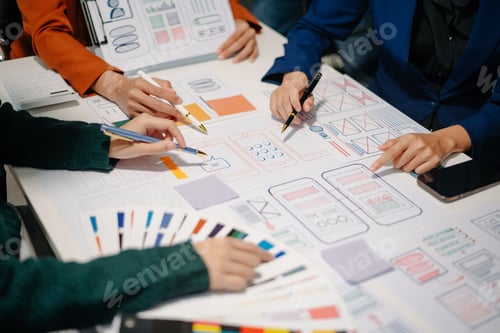 Preview: Close up view of UI developer team brainstorming on their project with laptop, smartphone