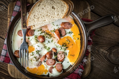 Preview: Tasty cooked egg with chopped sausages.