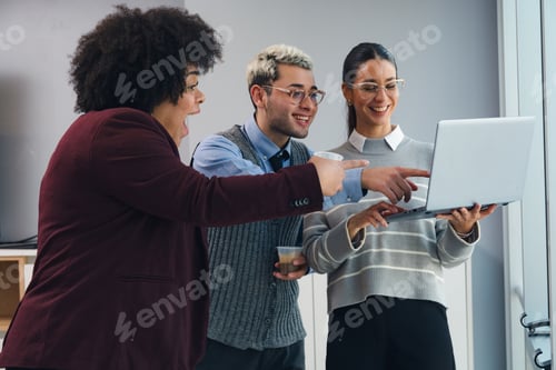 Preview: three people in the office looking at the laptop surprised by the economic profits of the month