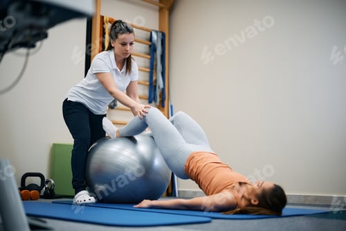 Preview: Woman Assists Patient with Exercise on Exercise Ball