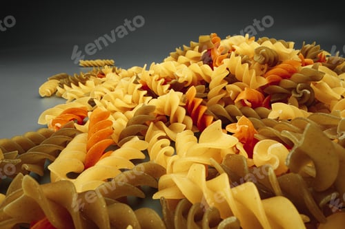 Preview: Uncooked pasta swirls on dark background macro
