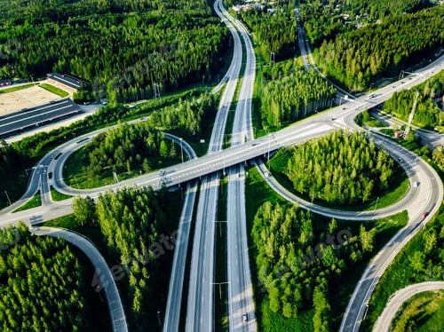 Preview: Aerial view of highway and overpass with green woods in Finland.