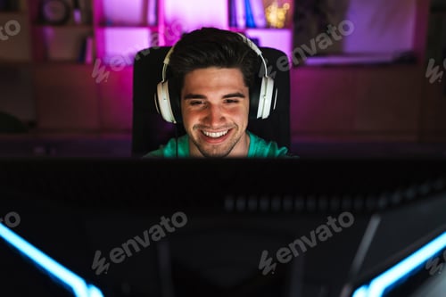Preview: Image of caucasian happy man playing video game on computer