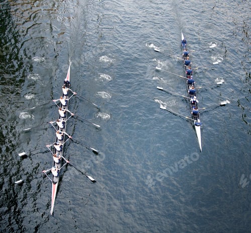 Preview: High angle view of two Eights rowing on river.