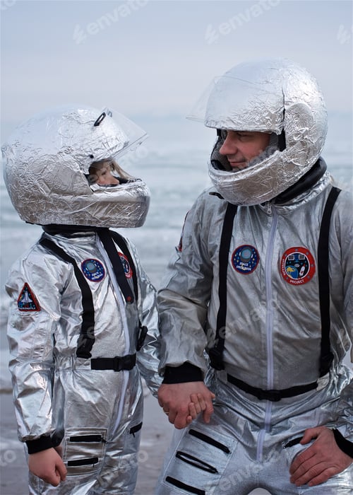 Preview: A boy and a young man in astronaut costumes look at each other