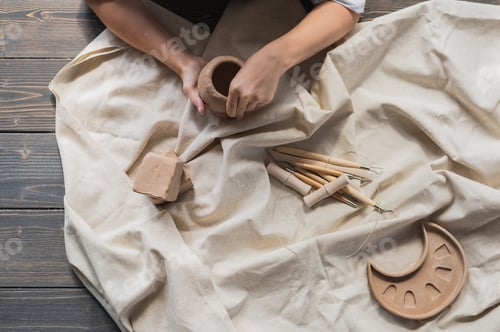 Preview: A young potter woman making pot in her own working place. Standing in spacious studio creating the