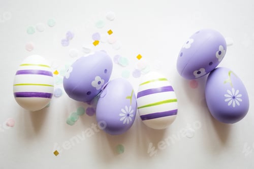 Preview: painted easter purple eggs with ornament and decor on white light pastel background. copy space