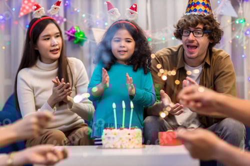 Preview: Celebrating Little girl birthday, blowing candles on homemade baked cake,