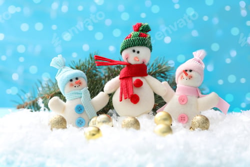 Preview: Cute toy snowmen, fir branch and Christmas balls on snow against blurred background