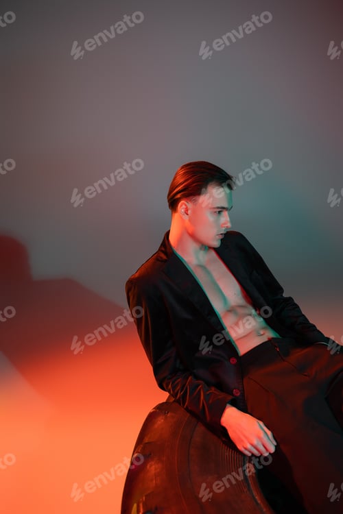 Preview: young and sexy man with brunette hair, wearing black blazer on shirtless muscular body, posing on