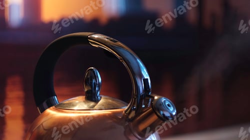 Preview: Polished kettle boiling on a gas stove in the kitchen in the evening. Concept. Close up of boiling
