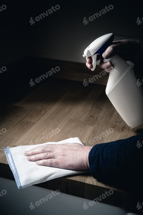 Preview: Close-up of a housewife cleaning a kitchen worksurface with antibacterial spray