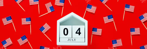 Preview: July 4th. Mockup of july 4 wooden color calendar and USA flags on red background. Independence Day