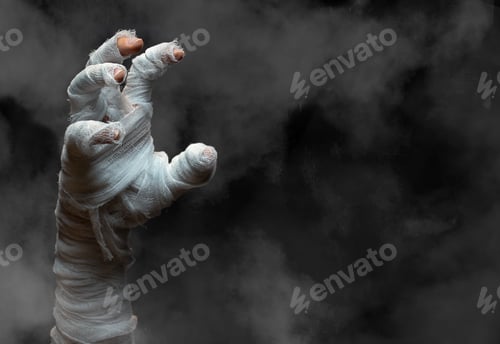 Preview: Halloween background.Bandaged zombie hand on dark smoky background.Halloween design.Copy space.