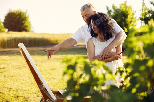 Visualização: Lindo casal adulto desenhando em um campo de verão