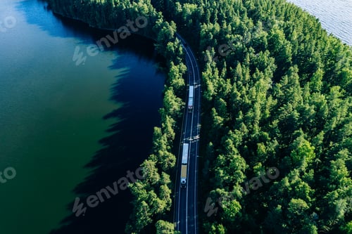 Preview: Aerial view of road in green woods and blue lakes water in Finland