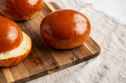 Preview: Homemade Brioche Hamburger Buns on a wooden board, low angle view. Close-up.
