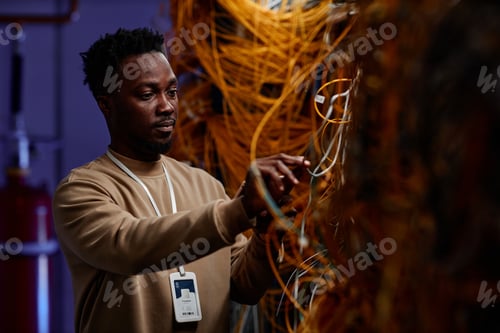 Preview: Black young man as system administrator setting up server network