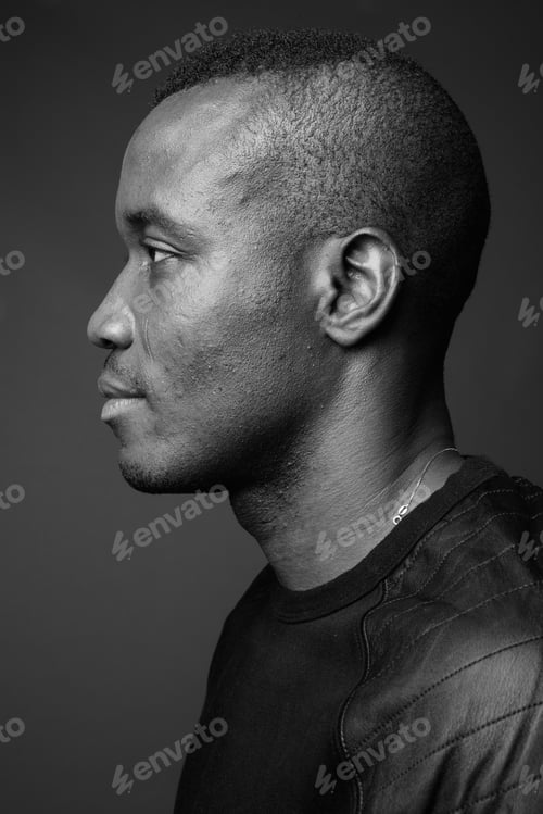 Preview: Studio shot of young African man against gray background