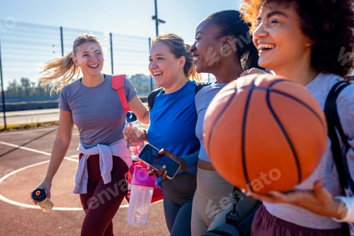 Preview: Diverse group of young woman walking on basketball court preparing to play.