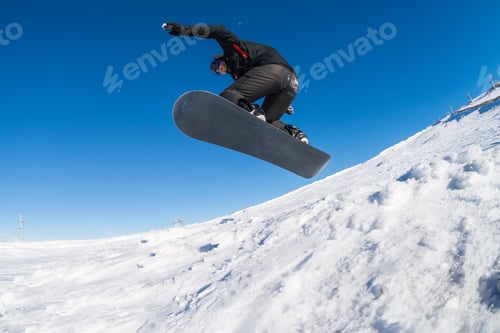 Vorschau: Snowboarder springt gegen blauen Himmel