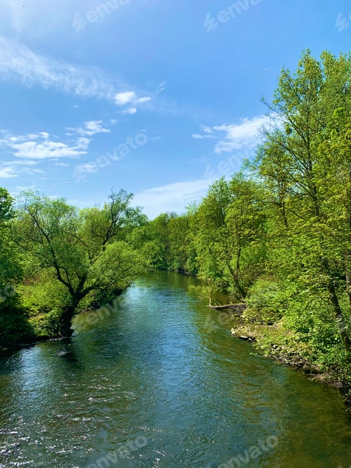 Preview: River flowing through lush green hillsides in the distance