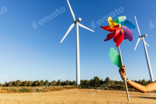 Preview: Person with pinwheel under a bright blue sky.