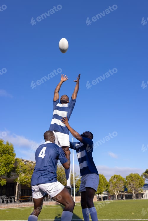 Preview: Three young African American men play rugby, one leaps for the ball