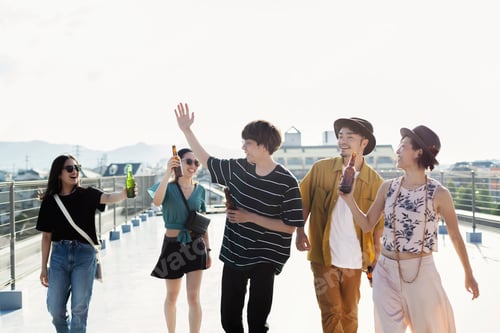 Preview: Group of young Japanese men and women standing on a rooftop in an urban setting.