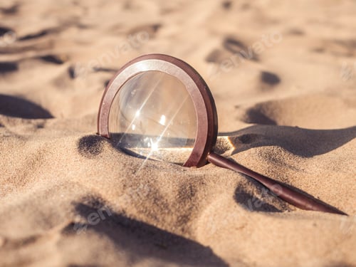 Preview: close up magnifier buried by sand on the beach