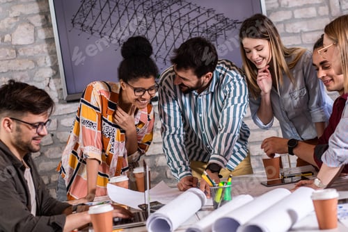 Preview: Group of modern business people in casual wear discussing architectural designs.