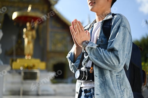 Preview: Cropped shot of man traveler praying and worship buddha in the buddhist temple.