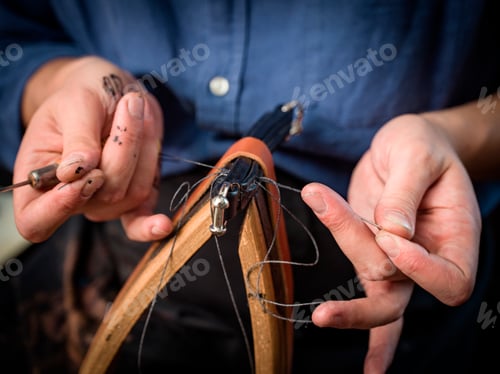 Preview: Leatherworker stitching handbag in workshop, close up of hands