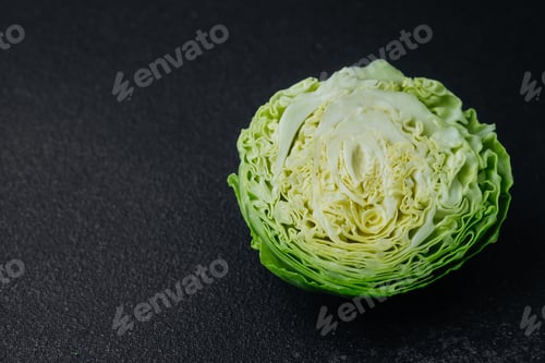 Preview: Detailed texture of halved cabbage on black surface