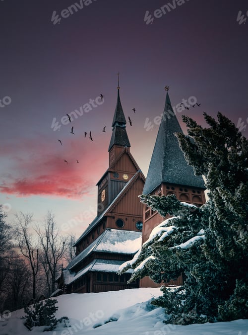Preview: Famous Stave church in Hahnenklee, Germany surrounded by trees covered in snow