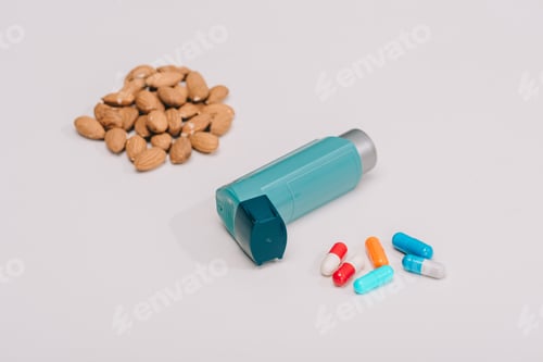 Preview: selective focus of pills and blue inhaler and tasty almonds near on grey
