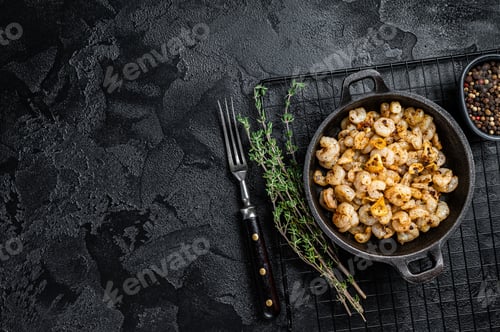 Preview: Roasted Shrimps with garlic, olive oil and spices in a skillet. Black background. top view.