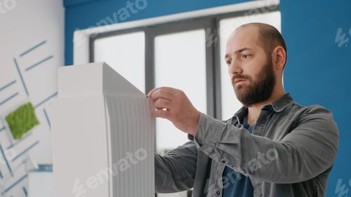 Preview: Close up of man engineer designing building model and maquette layout for architecture work