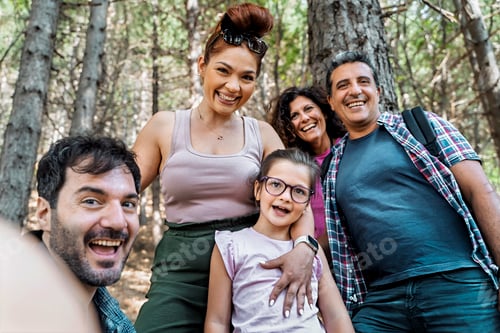 Preview: Happy multi-generational group of friends taking a fun selfie together while hiking in a forest