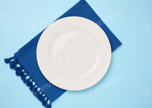 Preview: Round ceramic empty white plate and blue linen kitchen towel