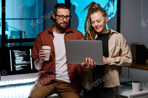 Preview: Happy female IT manager and her male colleague looking through data