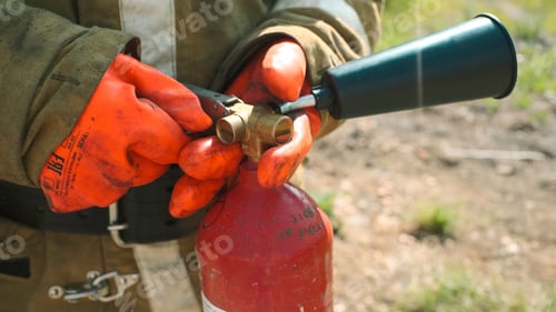 Preview: Close-up of firefighter with fire extinguisher. Clip. Firefighter picks up fire extinguisher and