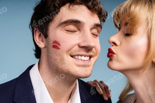 Preview: Elegant woman leaving lipstick kiss on smiling man