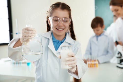 Preview: Schoolgirl making experiment in chemistry class, closeup