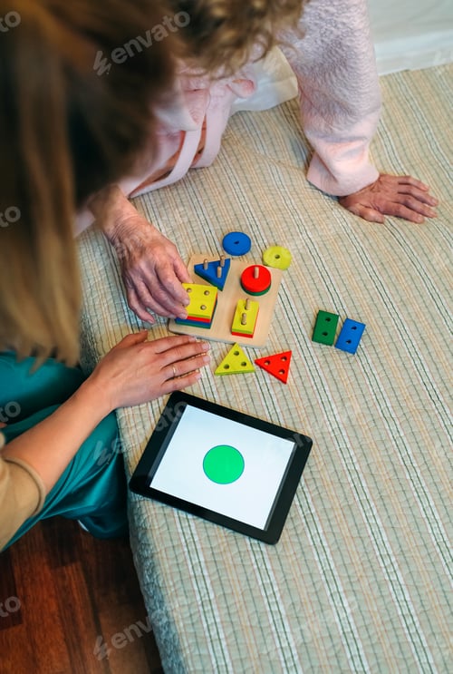 Preview: Female doctor showing geometric shapes to elderly patient