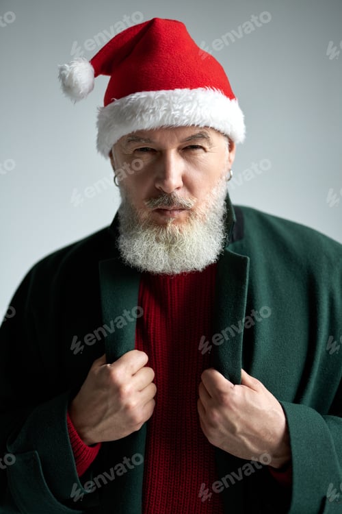 Preview: Focused middle aged man with Christmas hat wearing stylish outfit looking at camera, adjusting his