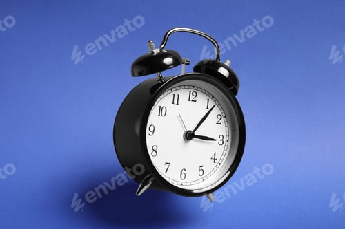 Preview: Black alarm clock in air on blue background