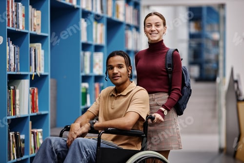 Preview: Smiling young woman assisting student with disability in library